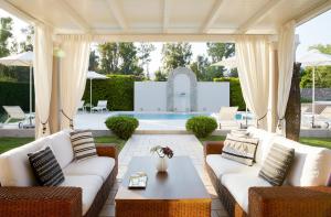 patio z kanapami, stołem i basenem w obiekcie S & O Villas Corfu w mieście Dassia