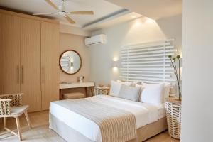 S & O Villas Corfu في داسيا: غرفة نوم بسرير وطاولة ومرآة