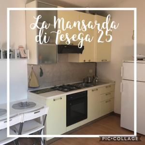 een keuken met een fornuis en een witte koelkast bij La Mansarda di Resega 25 in Villasanta