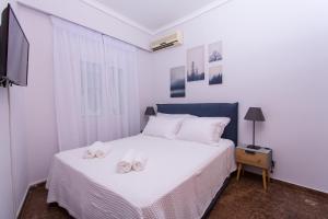 a bedroom with a bed with two slippers on it at Afaia houses in Aegina Town