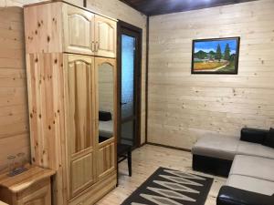 パンポロボにあるFamily Hotel Gingerの大きな木製キャビネットとソファが備わる客室です。