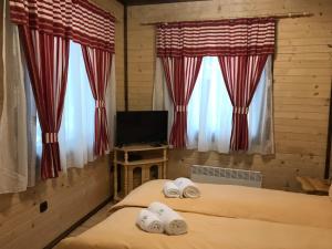a bedroom with two beds with towels on them at Family Hotel Ginger in Pamporovo