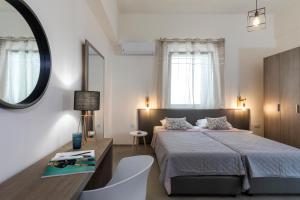 a bedroom with a bed and a desk and a mirror at Rose Central Master Bedroom Apartment in Rhodes Town