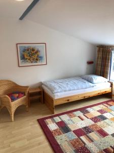 1 dormitorio con 1 cama, 1 silla y 1 alfombra en Apartment 1 oder 2 en Wyk auf Föhr