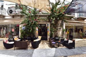 uma frente de loja com cadeiras e flores em frente a um edifício em Hotel Bejense em Beja