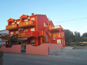 un edificio anaranjado con balcones en el lateral. en Apartments Drago, en Petrčane