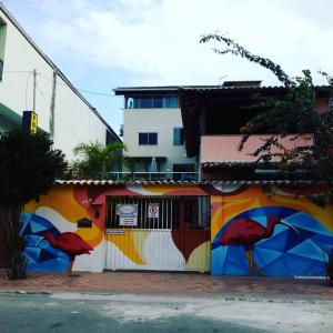 un bâtiment avec une fresque représentant des oiseaux sur son côté dans l'établissement Pousada Solar de Lourdes, à Guarapari