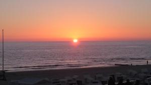 een zonsondergang op het strand met zonsondergang bij Ferienwohnung Meeresrausch in Westerland