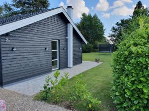 a small building with a patio next to a yard at Holiday home Als in Nordborg