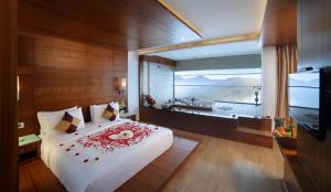 Amber Dale Luxury Hotel & Spa, Munnar في مونار: غرفة نوم مع سرير أبيض كبير مع نافذة كبيرة