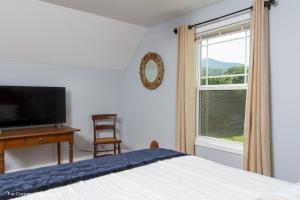 una camera da letto con un letto, una scrivania e una finestra di Mama Bears Blue Bungalow ad Asheville
