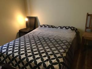 a bedroom with a bed with a black and white comforter at Suki Cafe Apartments in Canoa