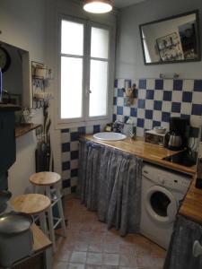 a kitchen with a sink and a washing machine at Almeria Garden Apartment in Paris