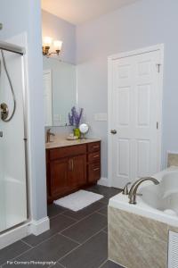 een badkamer met een bad, een wastafel en een douche bij Mama Bears Blue Bungalow in Asheville