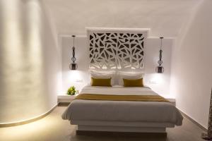 a bedroom with a large bed with yellow pillows at Margarita Hotel in Firostefani
