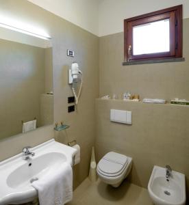 a bathroom with a sink and a toilet and a mirror at Hotel Sovestro in San Gimignano