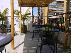 a patio with tables and chairs on a balcony at Hotel Maravillas del Mundo in Calpe