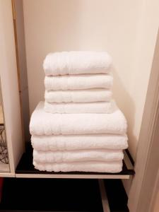 uma pilha de toalhas brancas numa prateleira em Residentie Ruytingen em Oostende