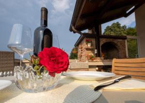 a table with a wine bottle and a vase with a red rose at Stella House Mrežnica in Duga Resa