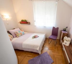 a small bedroom with a bed and a purple chair at Stella House Mrežnica in Duga Resa +48 photos