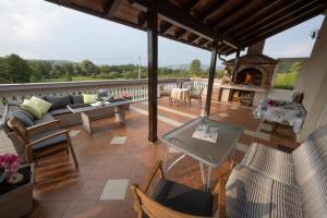 a patio with a couch and tables and a fireplace at Stella House Mrežnica in Duga Resa