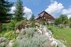 a house with a stone wall in front of a garden at Bran Belvedere International in Bran
