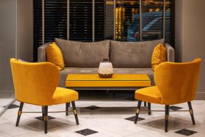 un soggiorno con sedie gialle e divano di Pantheon City Hotel a Gythio