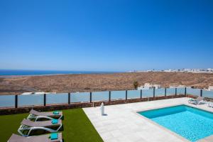 a swimming pool with a view of the ocean at Villa Honey Rose, Guime in Güime