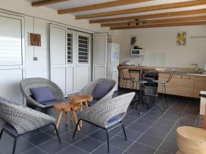 a room with chairs and a table and a kitchen at Domaine Choco Vanille in Deshaies