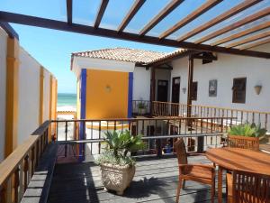 a balcony of a house with a table and chairs at Pousada Jataí in Cabo Frio