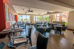a dining room with tables and chairs and windows at Crocs Resort & Casino in Jacó