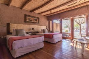 um quarto com 2 camas num quarto com uma mesa em Hotel Cumbres San Pedro de Atacama em San Pedro de Atacama mais 37 fotografias