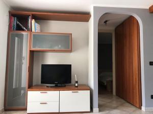a living room with a tv on a dresser and a room with a bed at Movisod 66 - Aosta in Aosta