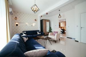 a living room with a blue couch and a table at Hotel Platinum in Ulcinj