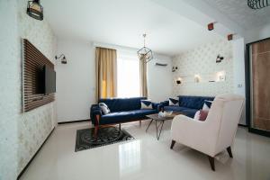 een woonkamer met een bank en een tafel en stoelen bij Hotel Platinum in Ulcinj