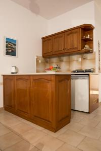 - une cuisine avec des placards en bois et un réfrigérateur blanc dans l'établissement Olga Apartments, à Alinda