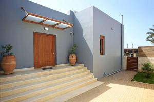 Una casa con escaleras y una puerta de madera en Villa Elpida, Kokkini Hani, en Kokkíni Khánion