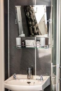 bagno con lavandino e specchio di Ladysmith Guest House a Ullapool