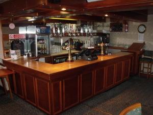 a bar with a wooden counter in a pub at Tafarn Y Rhos in Llangefni +12 photos