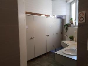 a bathroom with white cabinets and a sink at Bubble Hostel in Krakow