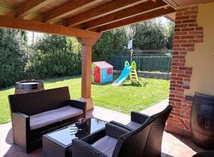 a patio with a table and chairs and a playground at LOS LAURELES in Cudón
