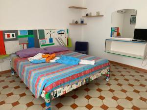 una camera da letto con un letto con un piumone colorato di Casa Manni Torre Suda a Racale