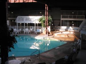 a pool at night with chairs and a table at Sturbridge Host Hotel And Conference Center in Sturbridge