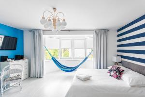 a bedroom with a bed and a hammock in front of a window at Hamak Apartamenty in Olsztyn