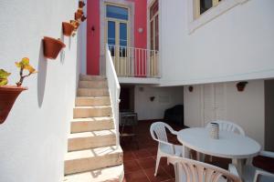 a room with a staircase and a table and chairs at Casa 11 Cravos in Figueira da Foz