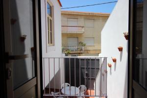 a balcony with a table and chairs and a building at Casa 11 Cravos in Figueira da Foz