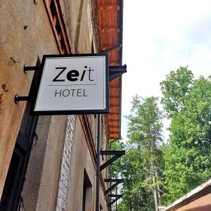 una señal para un hotel zett en el lado de un edificio en Zeit Hotel en Līgatne