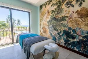 a bedroom with a large painting on the wall at Crocs Resort & Casino in Jacó