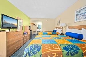 um quarto de hotel com uma cama grande e uma televisão de ecrã plano em Harris House by the Beach em Ocean City
