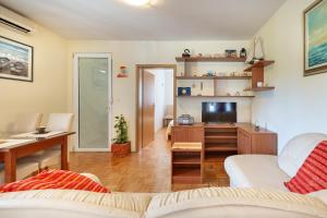sala de estar con sofá, TV y escritorio en Apartment Sweet, en Zadar